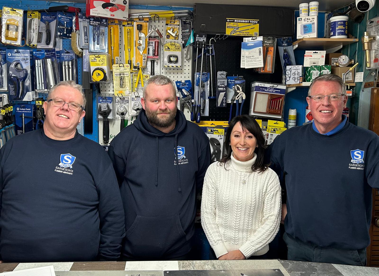 The friendly team at Sargeson’s Plumbers Merchants in Blackpool, standing inside their local plumbing and heating supplies shop, stocked with tools, boiler parts and trade essentials for customers across the Fylde Coast.